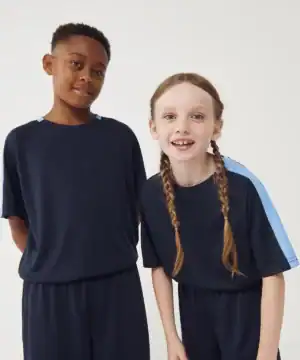 Two children wearing matching navy blue team t-shirts with light blue accents, smiling and standing.