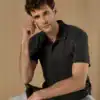 Man wearing a black regular fit Superwash polo shirt, casual style.