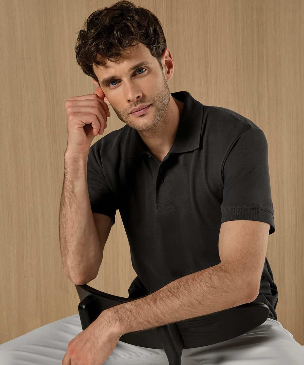 Man wearing a black regular fit Superwash polo shirt, casual style.