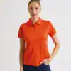 Women’s orange Coolchecker polo shirt with embroidered logo, perfect for casual or sportswear.