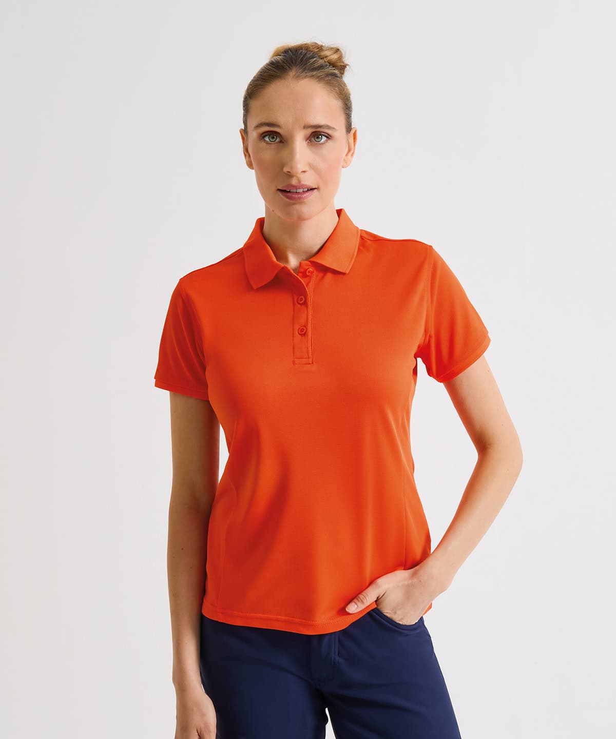 Women’s orange Coolchecker polo shirt with embroidered logo, perfect for casual or sportswear.