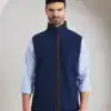 Man wearing navy blue embroidered fleece gilet with high collar and zip closure.