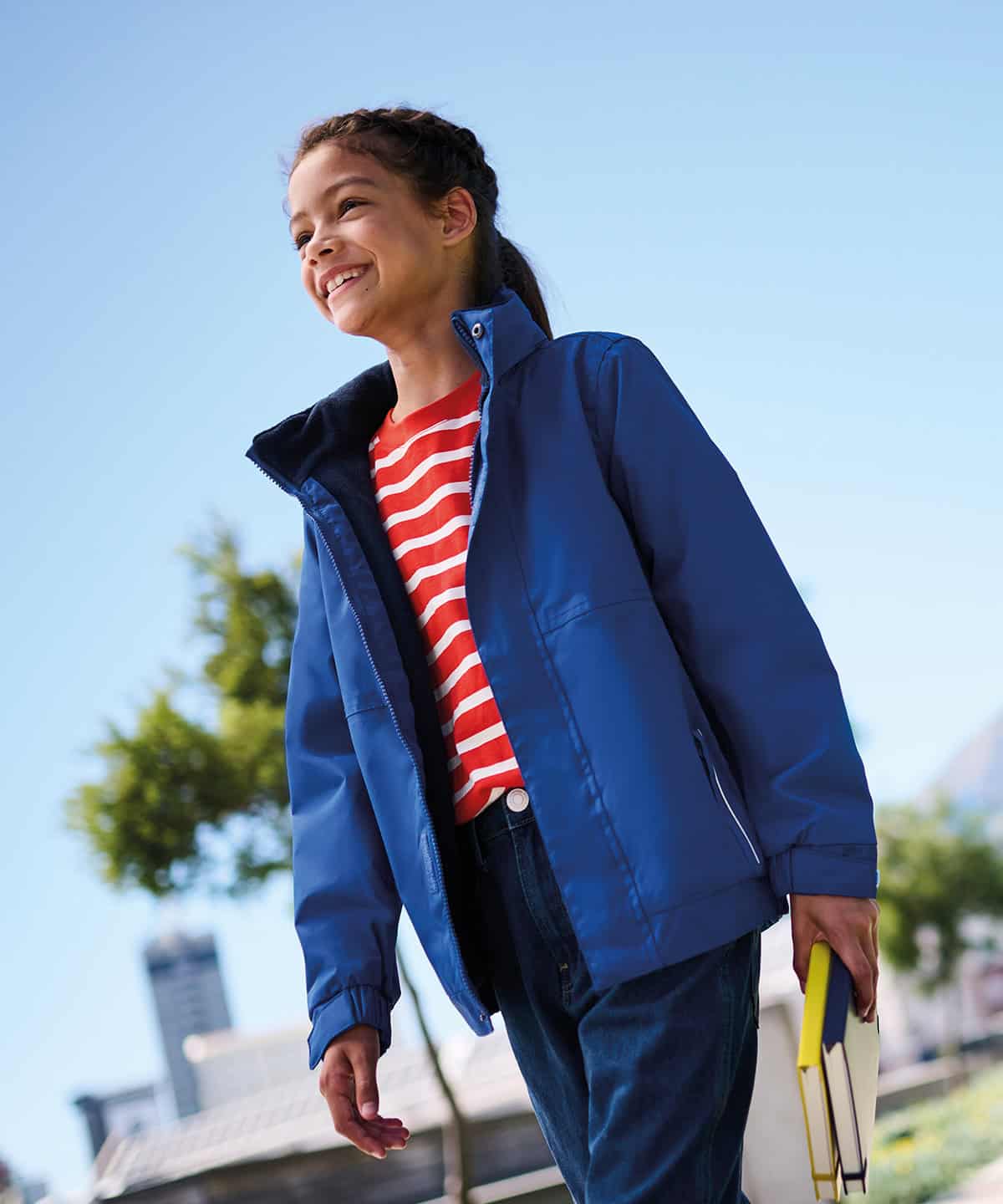Child wearing a blue Dover jacket outdoors on a sunny day.