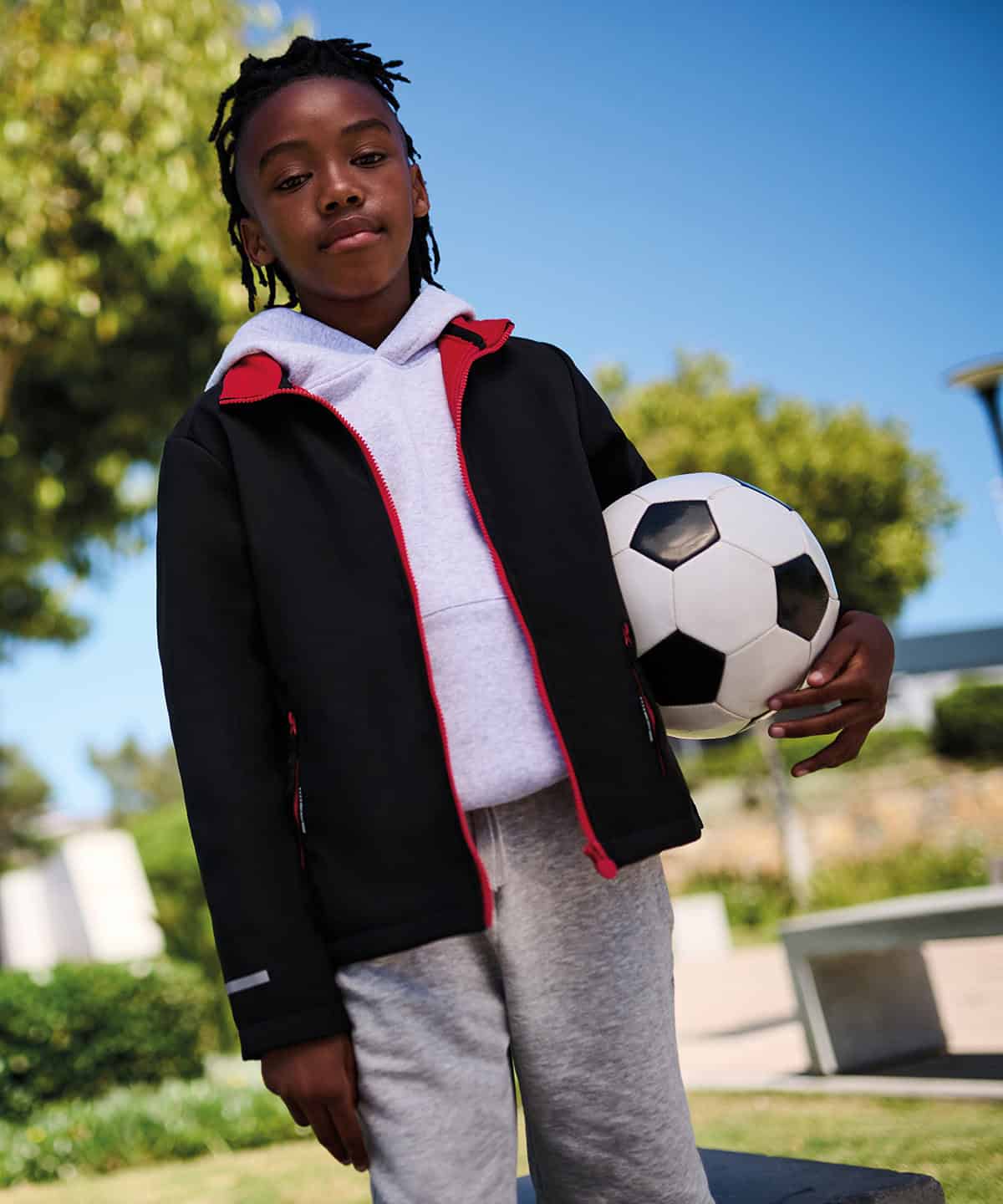 Bright kids' softshell jacket with vibrant red accents, perfect for outdoor activities.