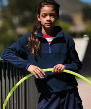 Girl wearing navy half-zip microfleece jacket outdoors, suitable for kids' casual wear.